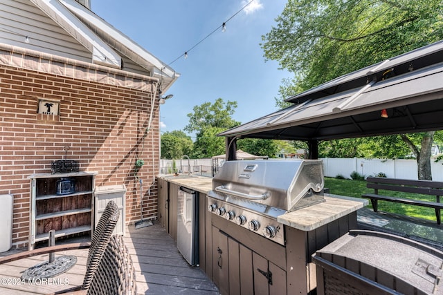 view of patio / terrace featuring an outdoor kitchen, a gazebo, fence, and grilling area