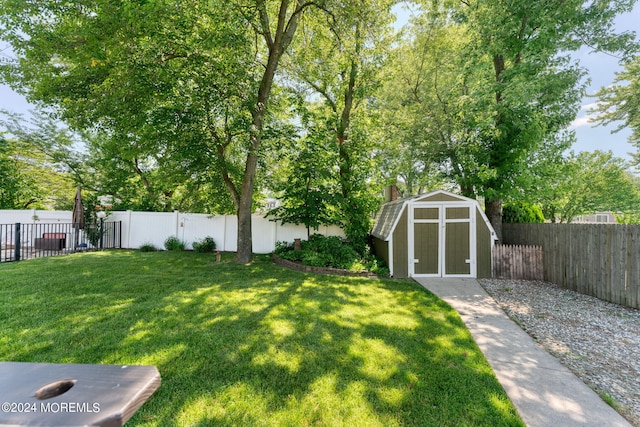 view of yard featuring an outbuilding, a storage shed, and a fenced backyard