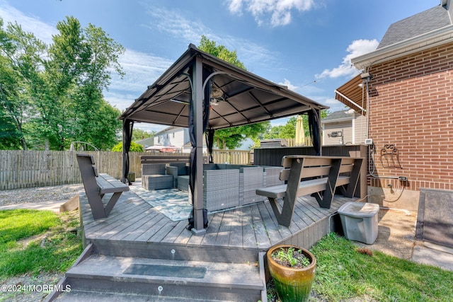 deck featuring a gazebo, fence, and an outdoor living space