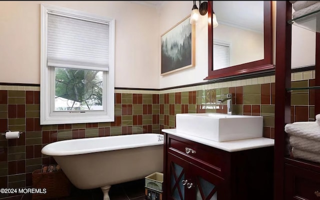 bathroom featuring vanity, tile walls, a freestanding tub, and a wainscoted wall