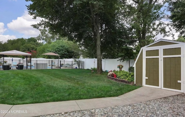 view of yard featuring an outbuilding, a storage unit, and a fenced backyard