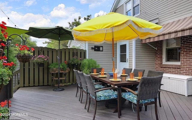 wooden deck with outdoor dining space and fence