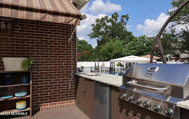 view of patio / terrace with grilling area, an outdoor kitchen, and fence