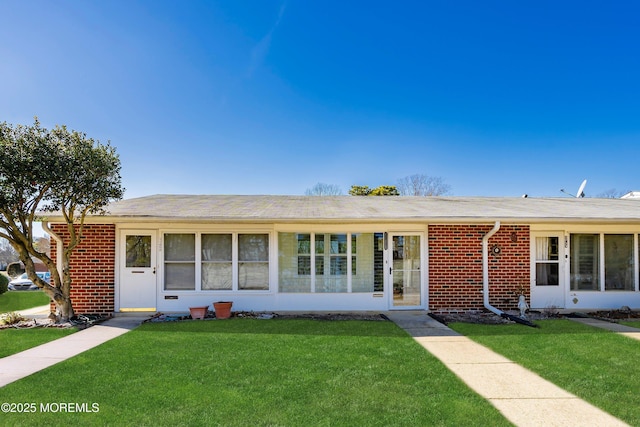 single story home featuring a front yard and brick siding