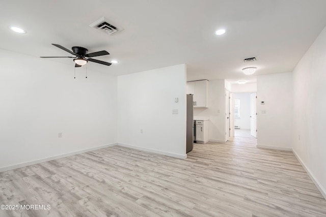 empty room featuring light wood-style floors, visible vents, and recessed lighting