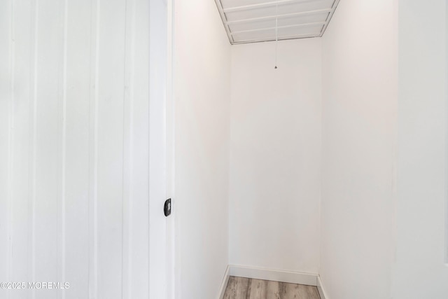 spacious closet featuring light wood-style flooring and attic access