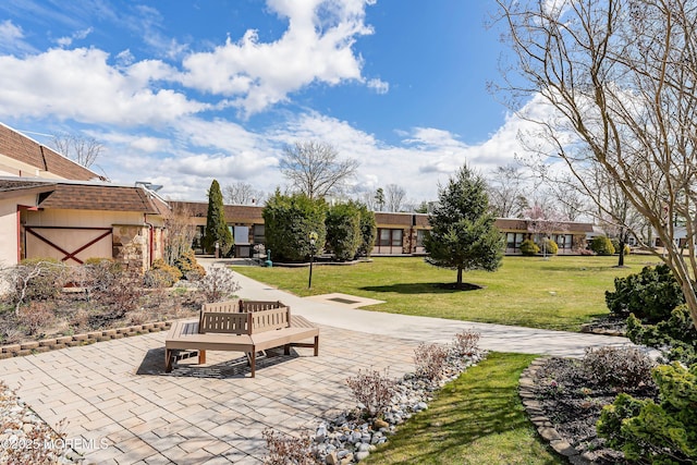 view of property's community featuring a yard and a patio area