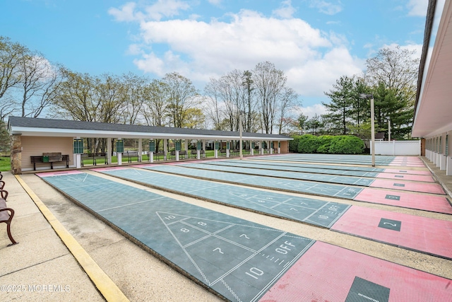 surrounding community with fence and shuffleboard