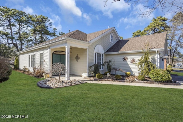 view of front facade with a front lawn and a shingled roof