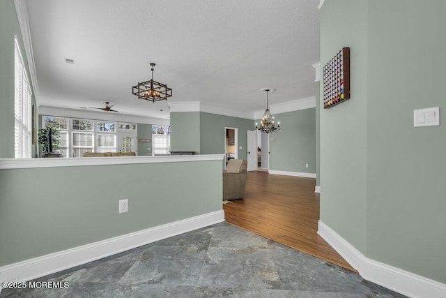 kitchen featuring ceiling fan with notable chandelier, hanging light fixtures, ornamental molding, and baseboards