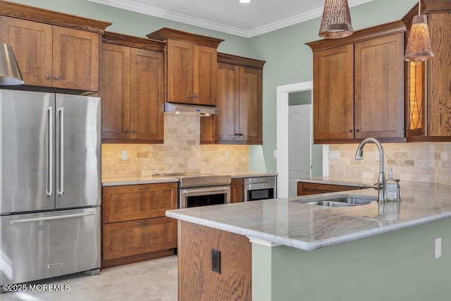 kitchen with under cabinet range hood, a sink, ornamental molding, appliances with stainless steel finishes, and brown cabinetry