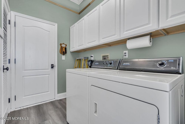 clothes washing area featuring cabinet space, washing machine and dryer, baseboards, and dark wood-type flooring