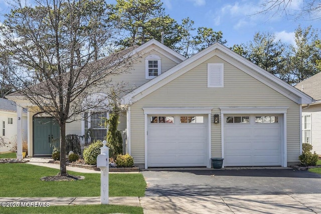 view of front facade with aphalt driveway and an attached garage