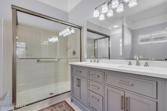 full bath featuring double vanity, a shower stall, ornamental molding, and a sink