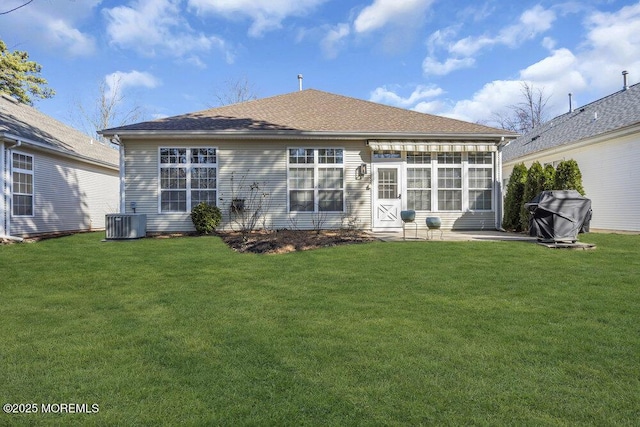 back of property featuring a yard, central AC unit, a patio area, and a shingled roof