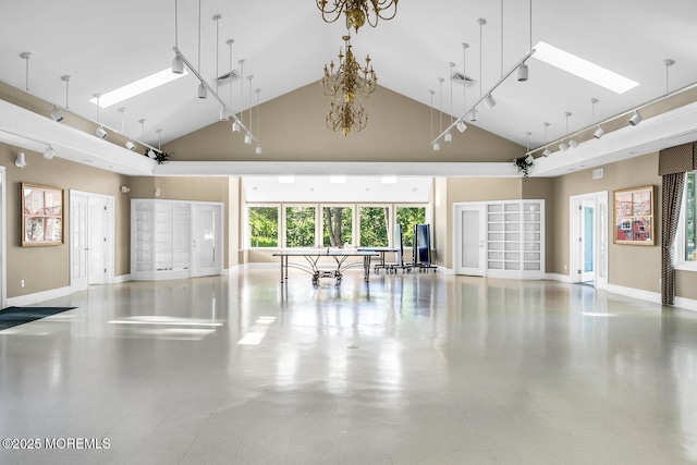 interior space with a skylight, baseboards, visible vents, and high vaulted ceiling