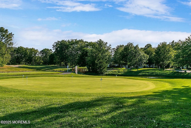 surrounding community featuring view of golf course and a lawn