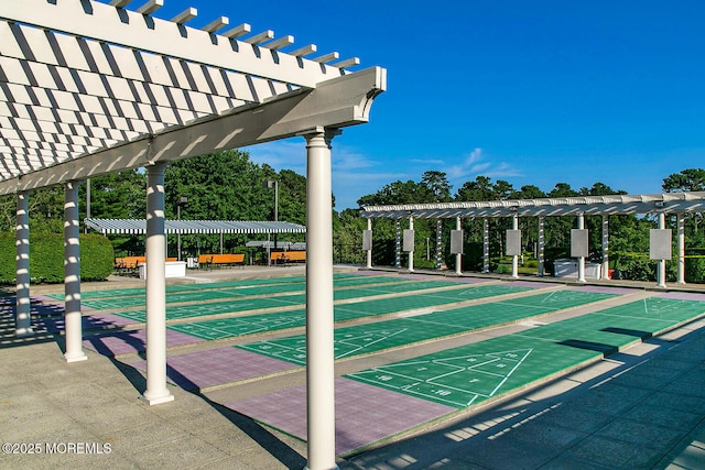 view of property's community featuring shuffleboard and a pergola