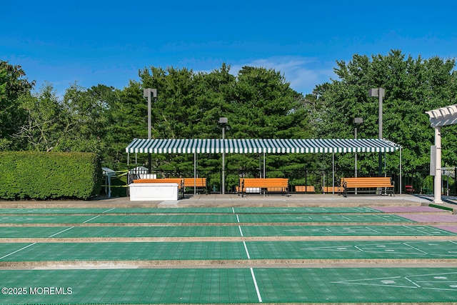 view of home's community featuring fence and shuffleboard