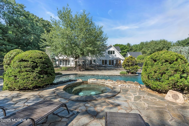 view of pool with a patio and a pool with connected hot tub