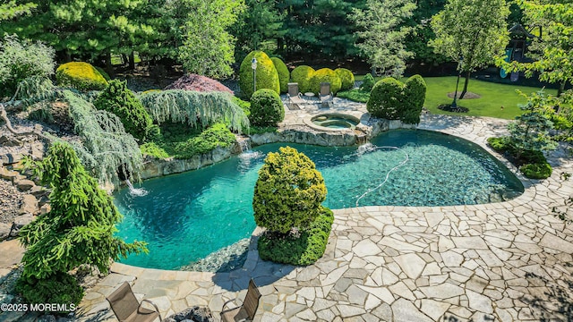 view of pool with a pool with connected hot tub and a yard