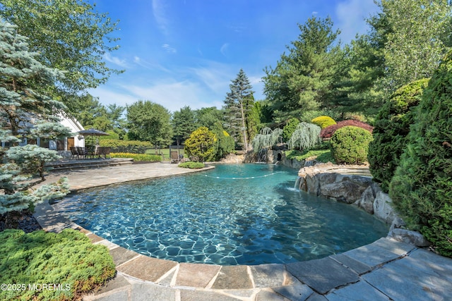 outdoor pool with a patio area