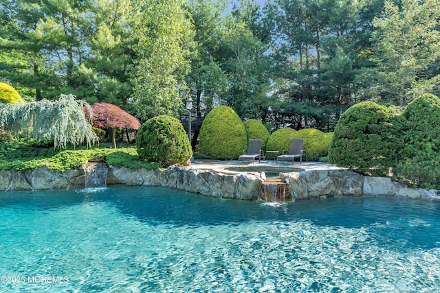 view of swimming pool featuring an in ground hot tub