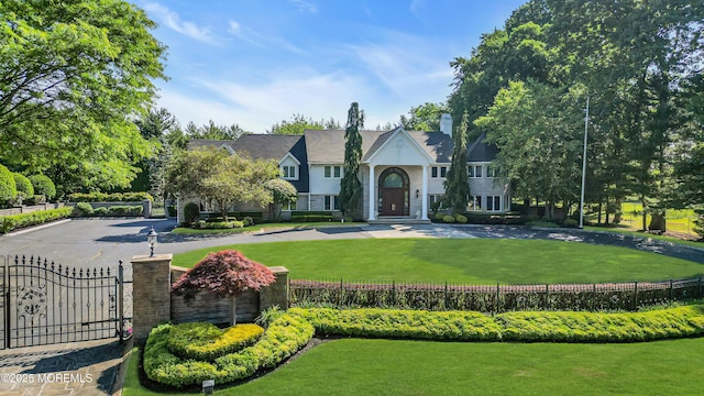 view of front facade featuring a fenced front yard, a front yard, and a gate