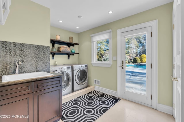 laundry room featuring visible vents, washing machine and dryer, recessed lighting, cabinet space, and a sink