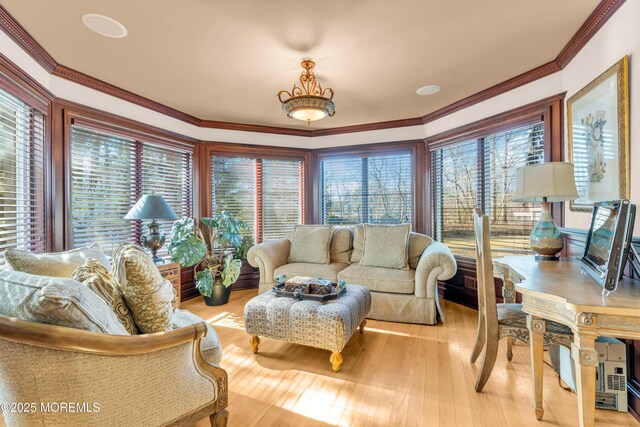 living room with wood finished floors and ornamental molding