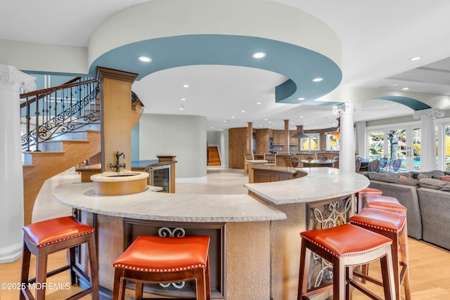 kitchen featuring recessed lighting, decorative columns, light wood-style floors, and open floor plan