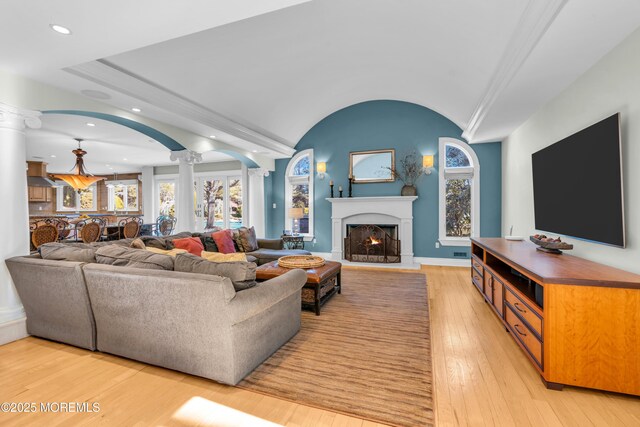 living room with recessed lighting, light wood finished floors, a healthy amount of sunlight, and ornate columns