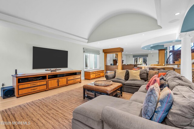 living area featuring lofted ceiling, decorative columns, recessed lighting, and light wood-type flooring