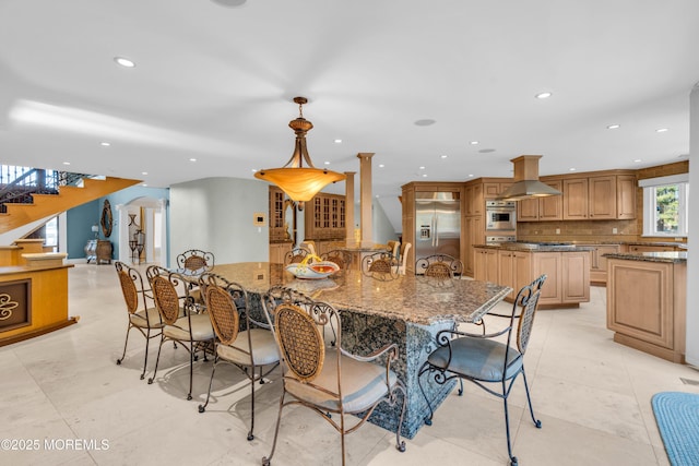 dining area featuring arched walkways, recessed lighting, stairs, and ornate columns