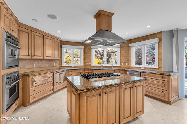 kitchen with island exhaust hood, stainless steel appliances, a warming drawer, and decorative backsplash