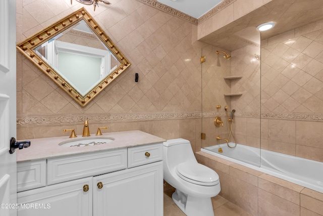 bathroom featuring vanity, tiled shower / bath combo, tile walls, toilet, and tile patterned floors