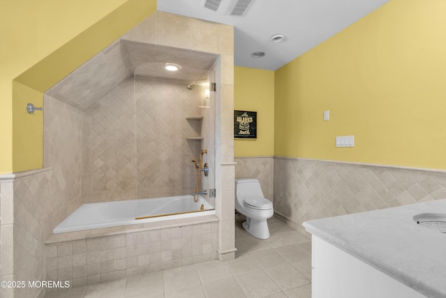 full bathroom featuring tile patterned floors, toilet, tile walls, wainscoting, and vanity