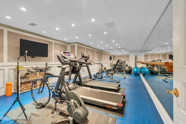 workout area with a decorative wall, recessed lighting, and visible vents