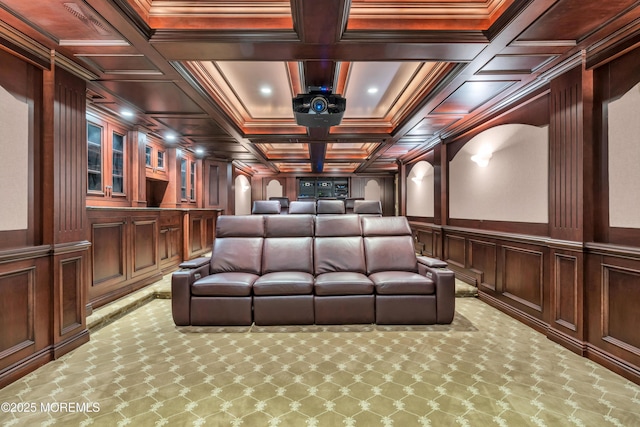 cinema featuring carpet floors, coffered ceiling, ornamental molding, and a decorative wall