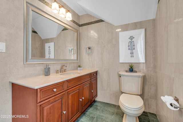 bathroom featuring tile patterned floors, toilet, tile walls, lofted ceiling, and vanity