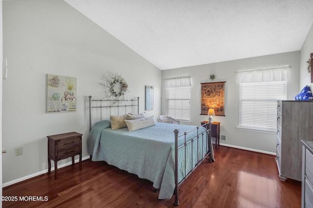 bedroom with dark wood-style flooring, vaulted ceiling, a textured ceiling, and baseboards