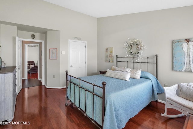 bedroom with lofted ceiling, dark wood-type flooring, and baseboards