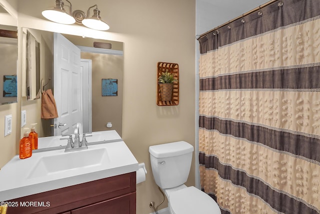 bathroom with curtained shower, vanity, and toilet