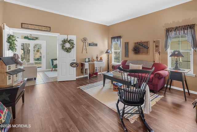 living room featuring ornamental molding, baseboards, and hardwood / wood-style floors