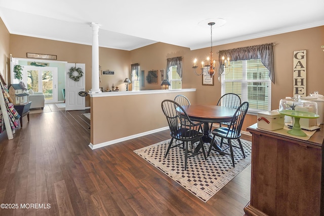 dining area featuring dark wood-style flooring, baseboards, an inviting chandelier, decorative columns, and crown molding