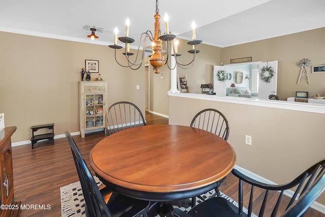 dining space with baseboards, a chandelier, wood finished floors, and crown molding