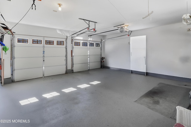 garage featuring a garage door opener and baseboards