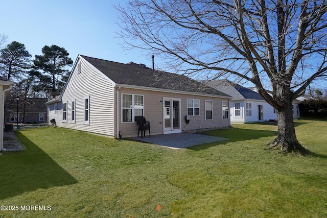 back of property featuring a yard, roof with shingles, and a patio area