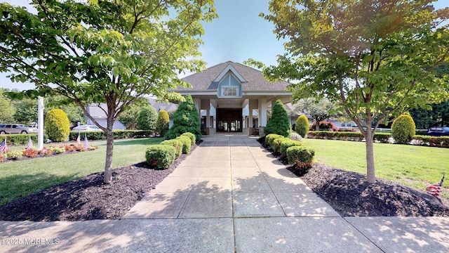 view of front of property with roof with shingles and a front yard