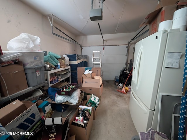 garage featuring white refrigerator with ice dispenser and a garage door opener